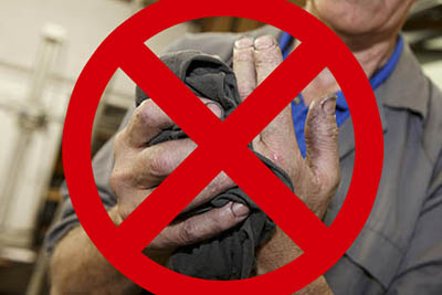 operador limpando a mão com pano sujo e contaminado e possibilidade de dermatite causada por fluido lubrificante